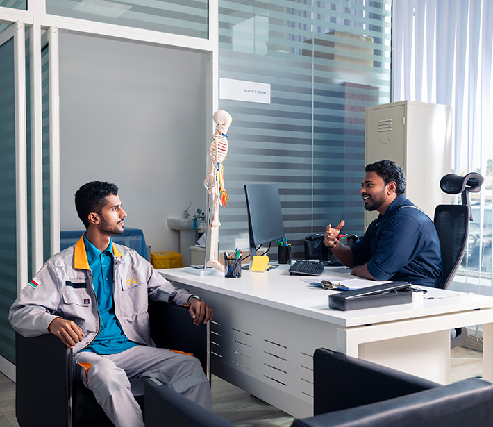 two colleagues chatting at a desk